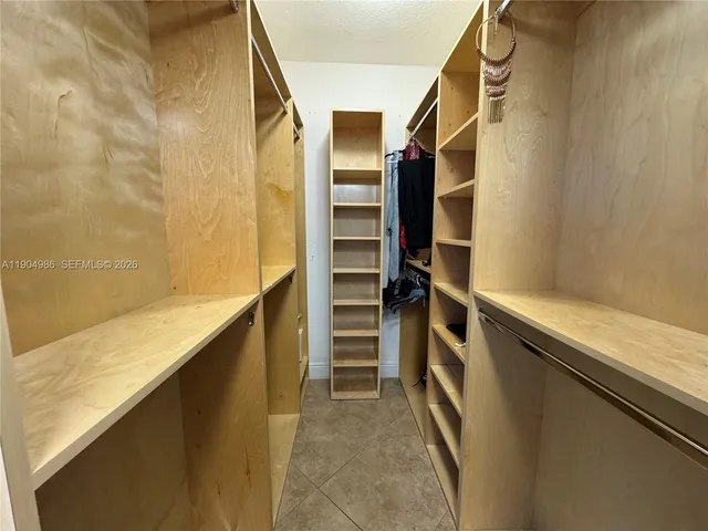 a view of walk in closet with clothes