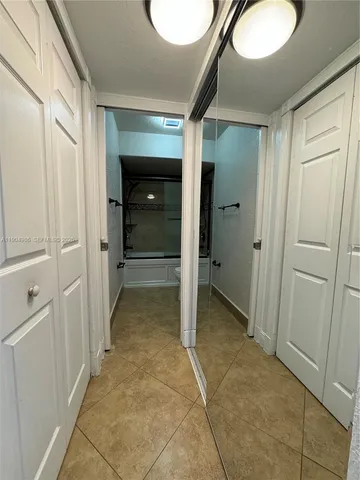 a view of a hallway with closet and bathroom