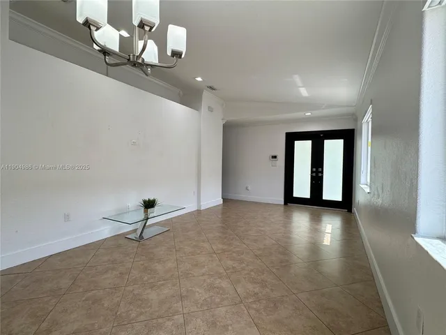 an empty room with projector and white walls