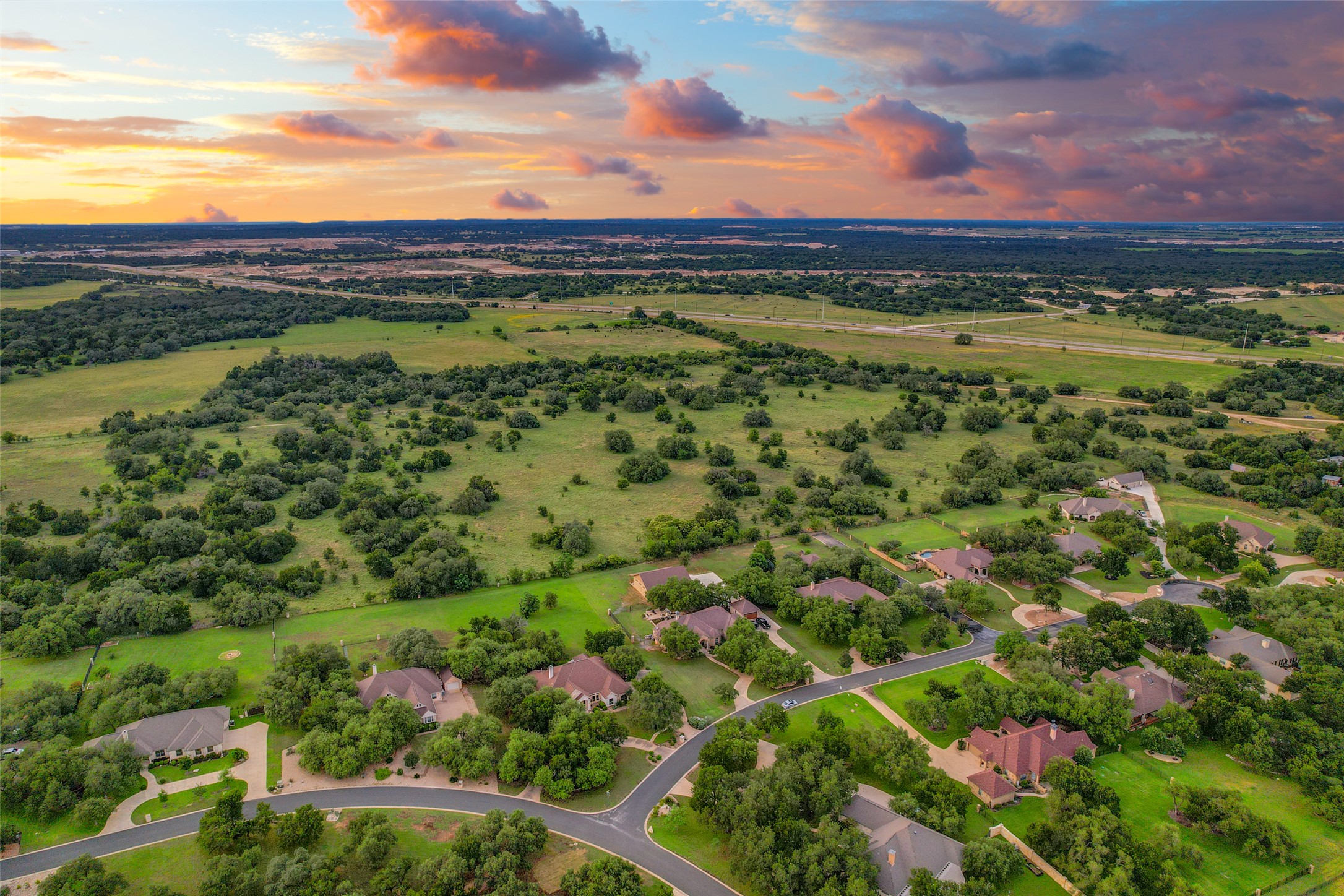 101 Copper Leaf Court Georgetown, TX 78633 - Photo 27 of 31 Aerial landscape featuring a residential area with varied architectural styles, mature green trees, and paved streets