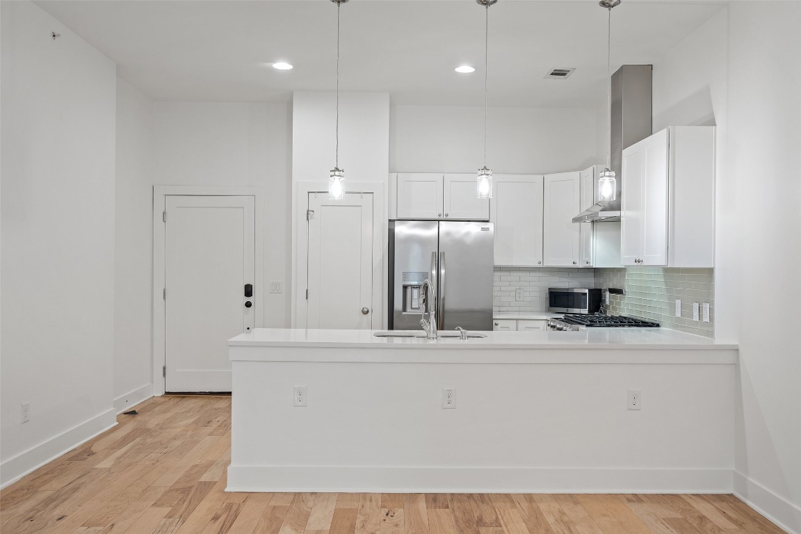 a kitchen with kitchen island stainless steel appliances a sink a stove a refrigerator and cabinets