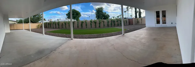 a view of a house with a floor to ceiling window and a fence