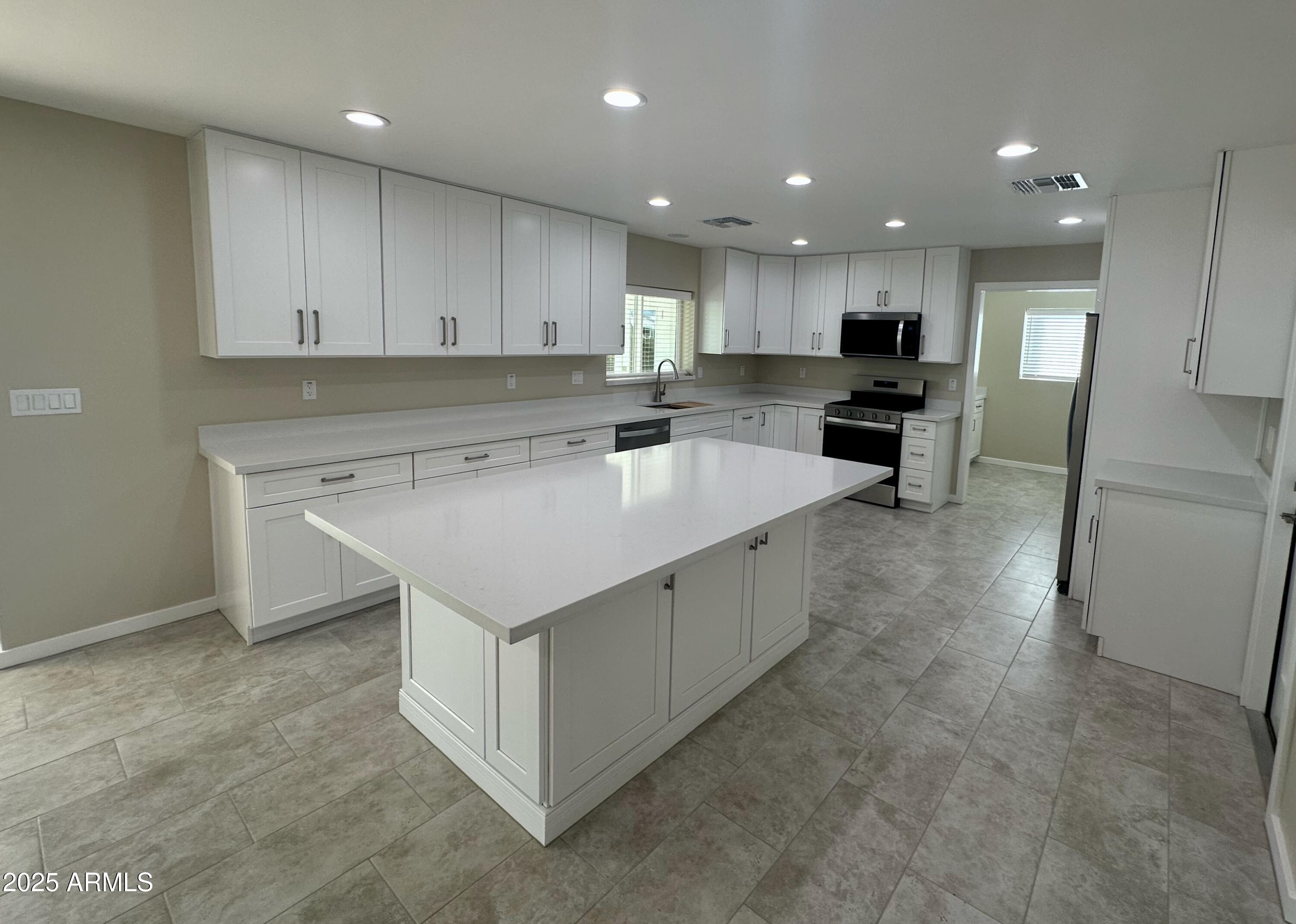 2329 East Enrose Street Mesa, AZ 85213 - Photo 6 of 30 a kitchen with a sink stove and cabinets