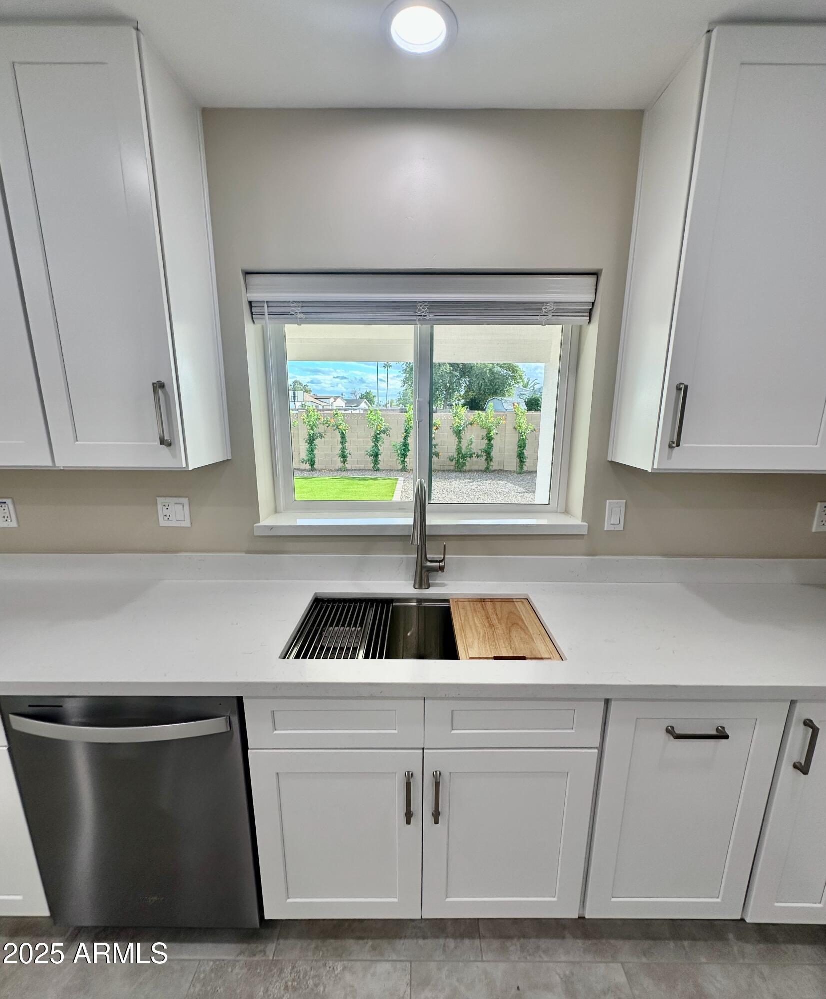 2329 East Enrose Street Mesa, AZ 85213 - Photo 8 of 30 a kitchen with white cabinets a sink and a window