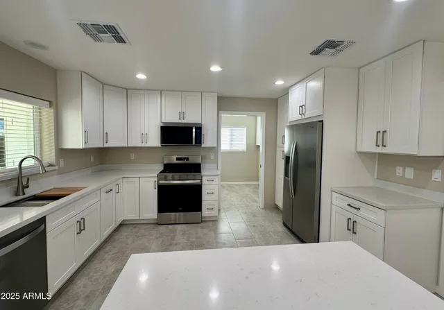 a kitchen with stainless steel appliances a refrigerator sink microwave and cabinets