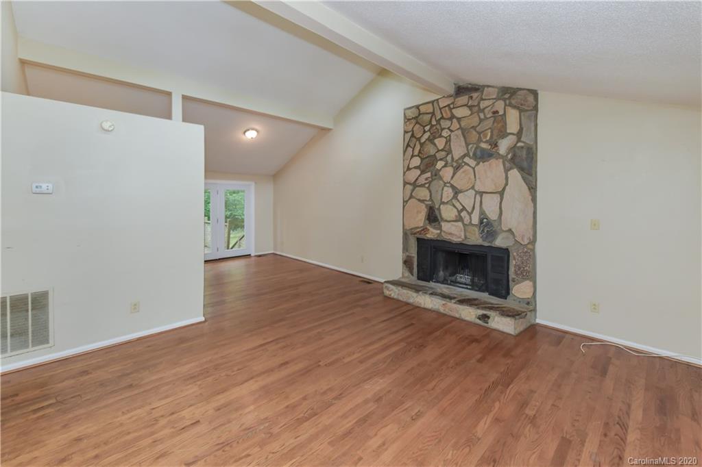 9209 Fairway Ridge Road Charlotte, NC 28277 - Photo 22 of 48 an empty room with wooden floor and a fireplace
