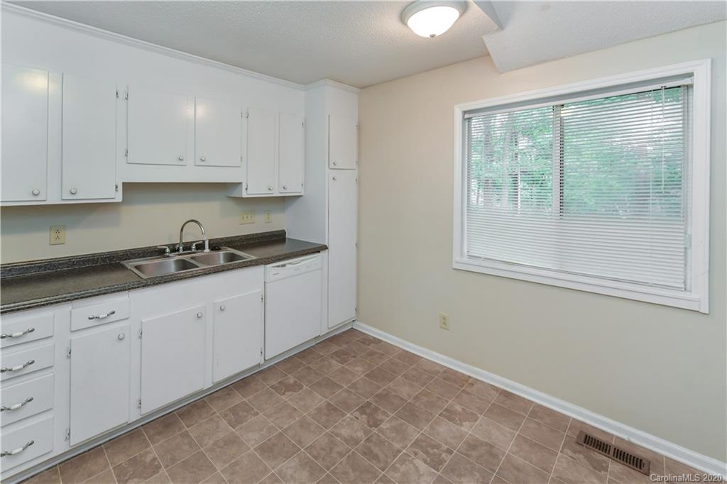 9209 Fairway Ridge Road Charlotte, NC 28277 - Photo 40 of 48 a kitchen with granite countertop white cabinets and window