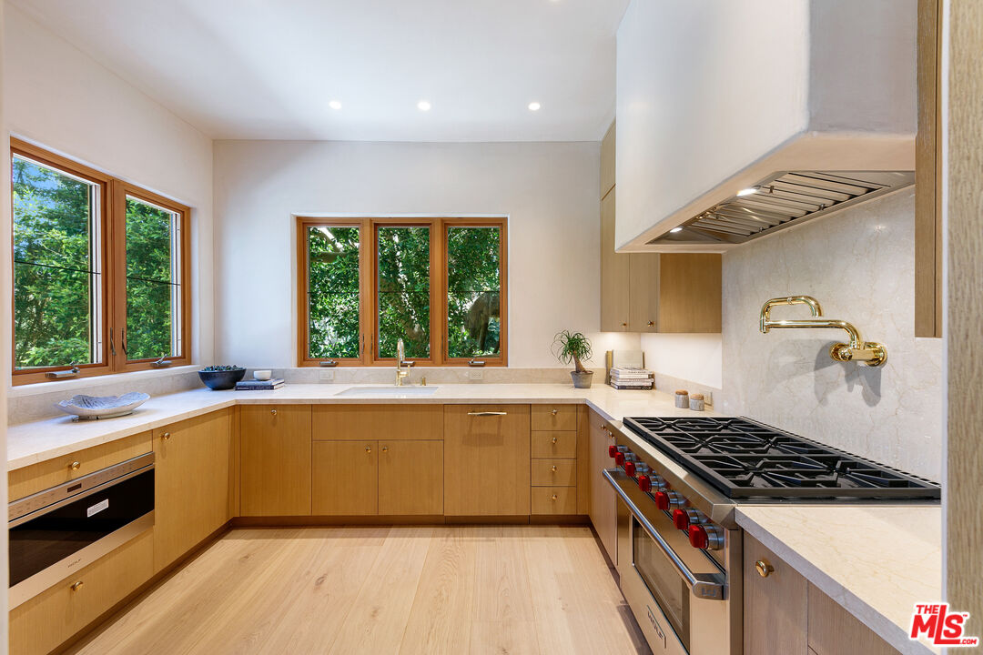 6902 Wildlife Road Malibu, CA 90265 - Photo 12 of 41 a kitchen with a sink a stove top oven and cabinetry