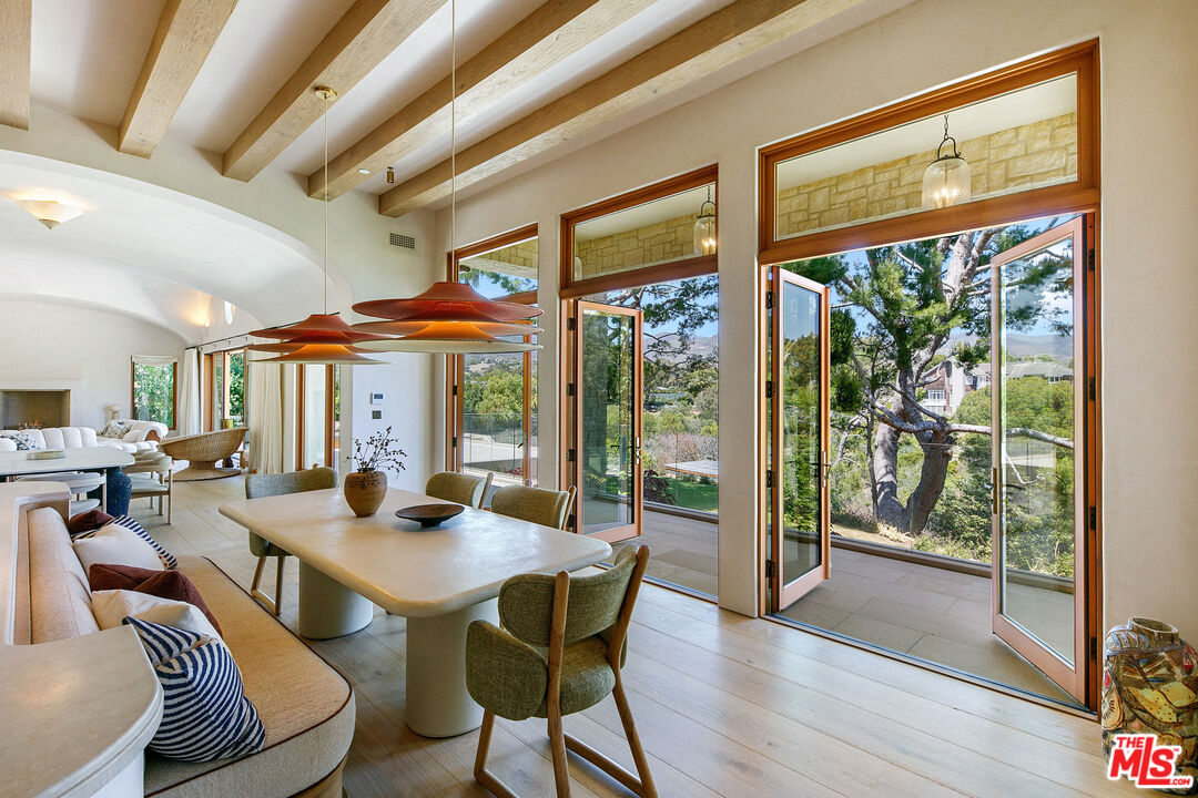 6902 Wildlife Road Malibu, CA 90265 - Photo 13 of 41 a view of a dining room with furniture large windows and wooden floor