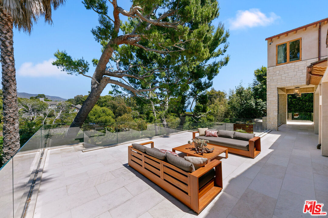 6902 Wildlife Road Malibu, CA 90265 - Photo 14 of 41 a backyard of a house with fountain table and chairs