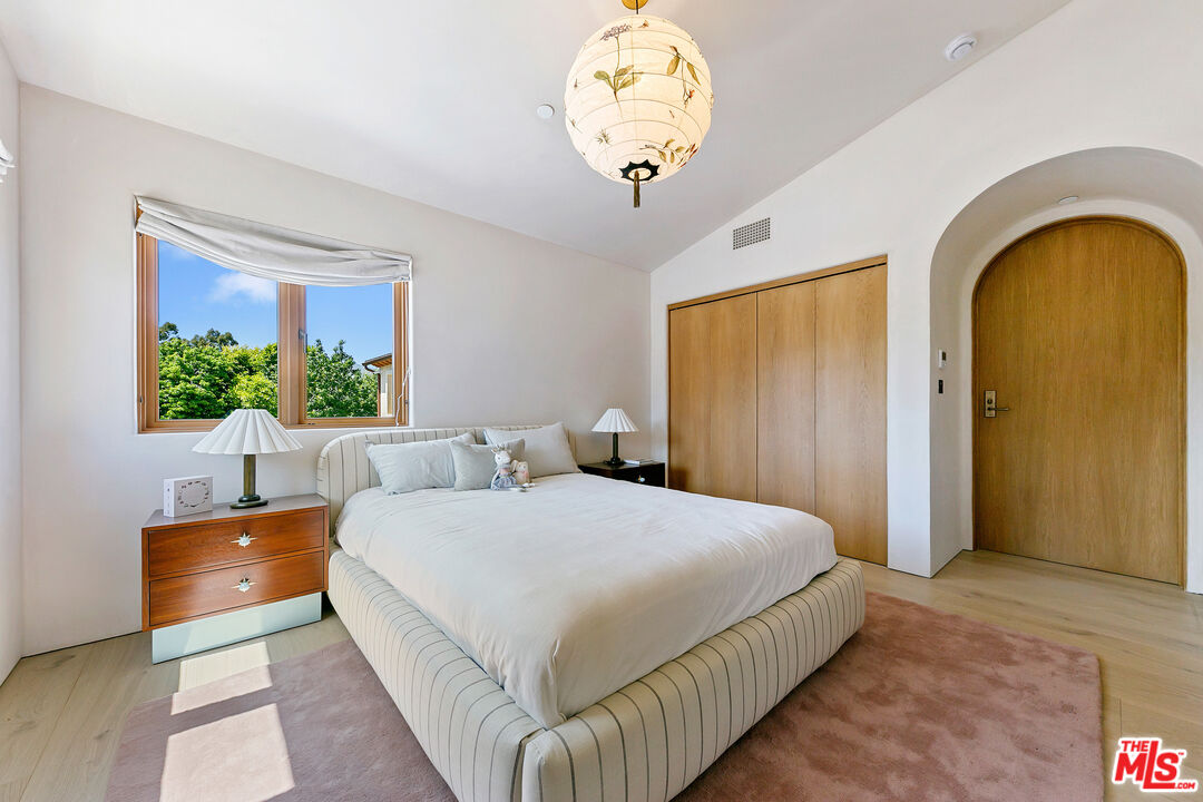 6902 Wildlife Road Malibu, CA 90265 - Photo 24 of 41 a spacious bedroom with a bed and a chandelier