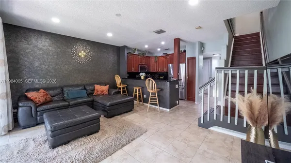 a living room with furniture and kitchen view