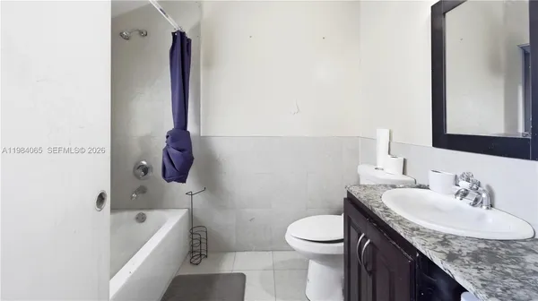 a bathroom with a granite countertop sink a toilet and bathtub