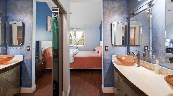 a en suite bathroom with a granite countertop sink and a mirror