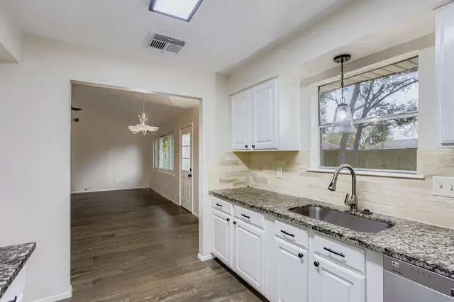 a kitchen with granite countertop a sink and cabinets