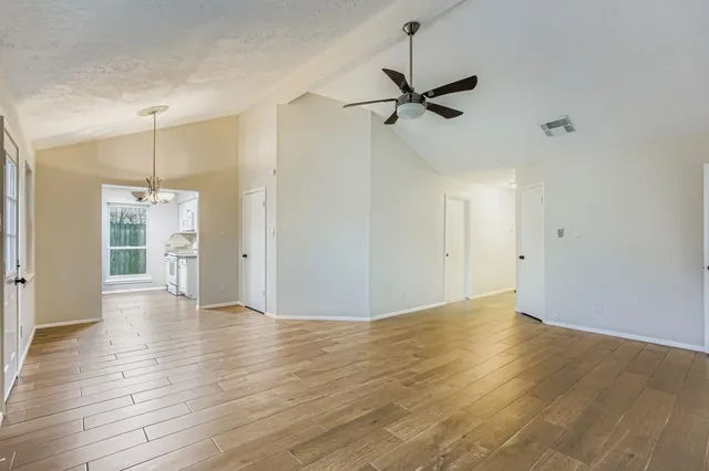 a view of an empty room with wooden floor
