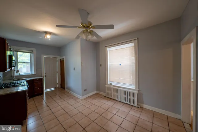 a view of an empty room with window and cabinet
