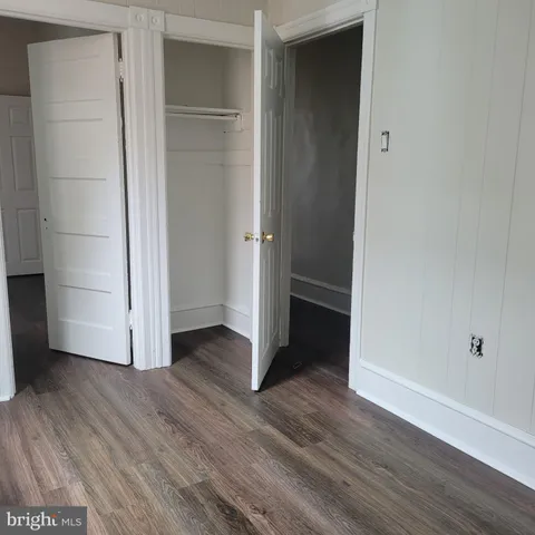 an empty room with wooden floor & closet
