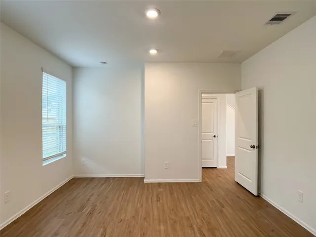 an empty room with wooden floor and window