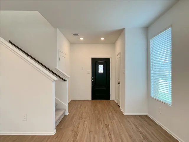 a view of a kitchen with a sink and dishwasher a refrigerator with wooden floor
