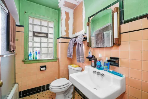 a bathroom with a sink a toilet and a window