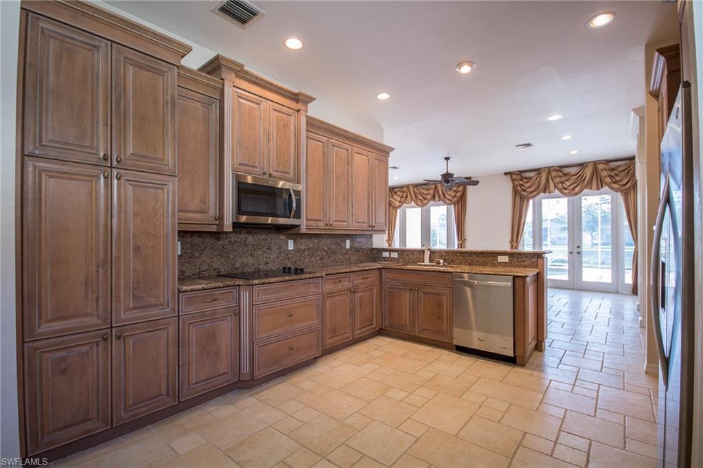 9337 Springview Loop Estero, FL 33928 - Photo 11 of 25 a kitchen with stainless steel appliances granite countertop a refrigerator and microwave