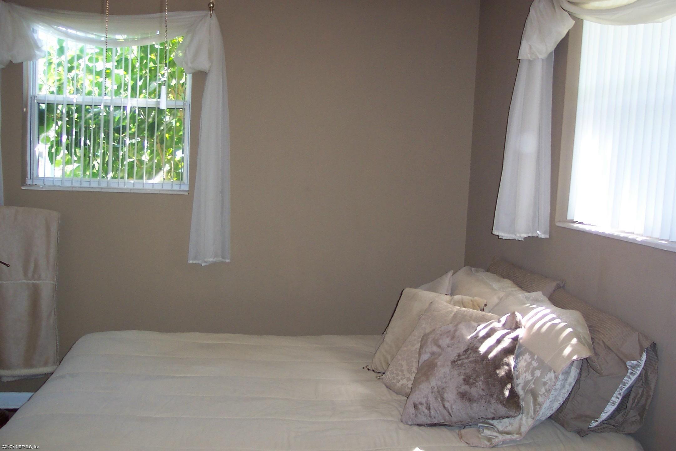 2806 Randy Road Jacksonville, FL 32216 - Photo 8 of 10 a bed sitting in a bedroom next to a window