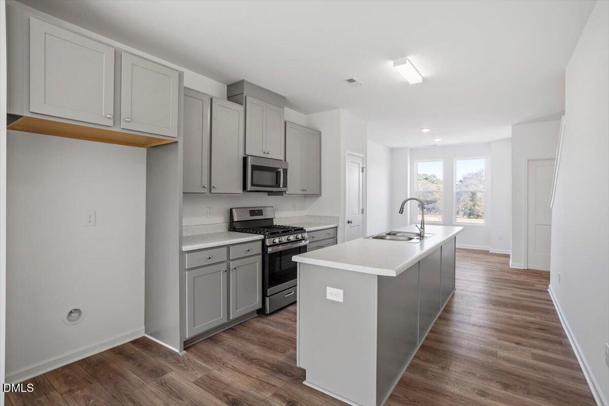 443 North Fisher Street Raleigh, NC 27610 - Photo 13 of 33 a kitchen with stainless steel appliances granite countertop a sink stove and refrigerator