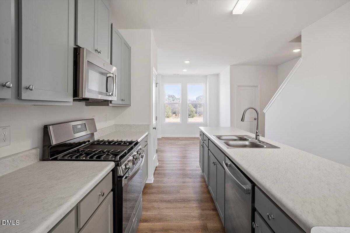 443 North Fisher Street Raleigh, NC 27610 - Photo 15 of 33 a kitchen with kitchen island a sink stove top oven and cabinets