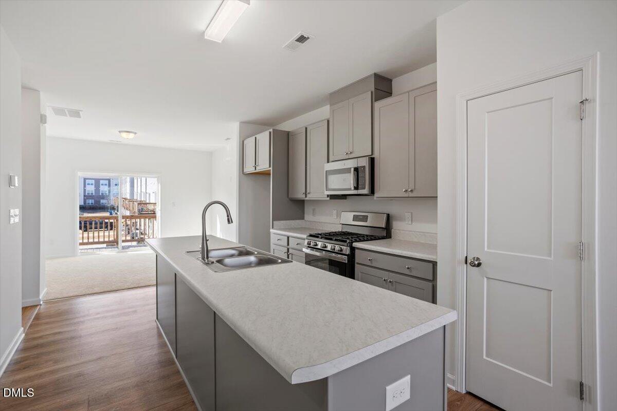 443 North Fisher Street Raleigh, NC 27610 - Photo 17 of 33 a kitchen that has stainless steel appliances a sink a stove and white cabinets