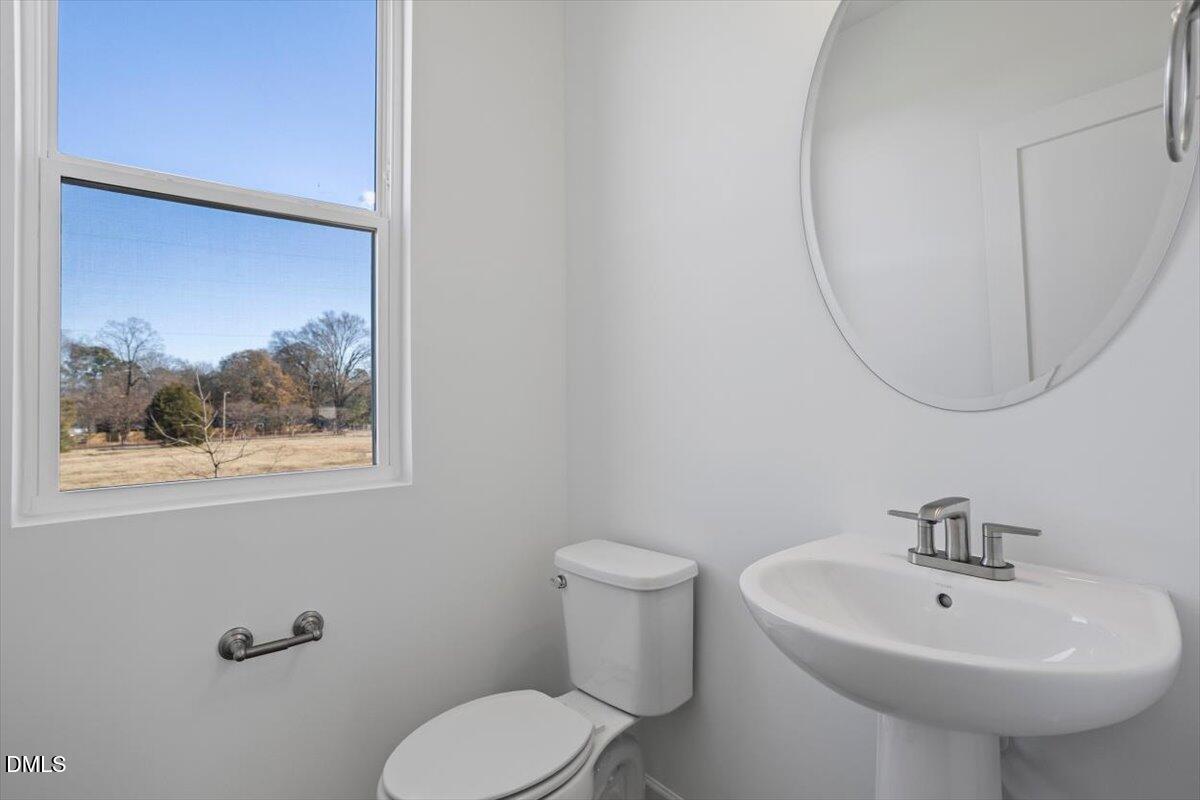 443 North Fisher Street Raleigh, NC 27610 - Photo 21 of 33 a bathroom with a sink a mirror and a toilet