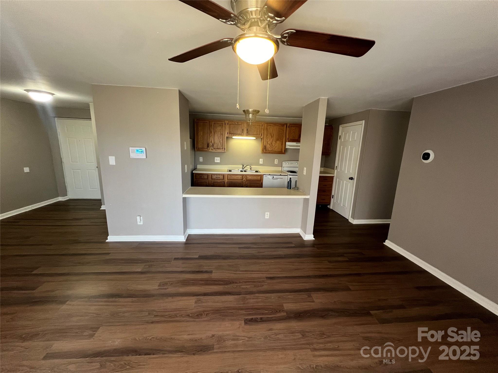 9401 Old Concord Road, Unit K Charlotte, NC 28213 - Photo 3 of 12 a view of a kitchen with wooden floor and a ceiling fan
