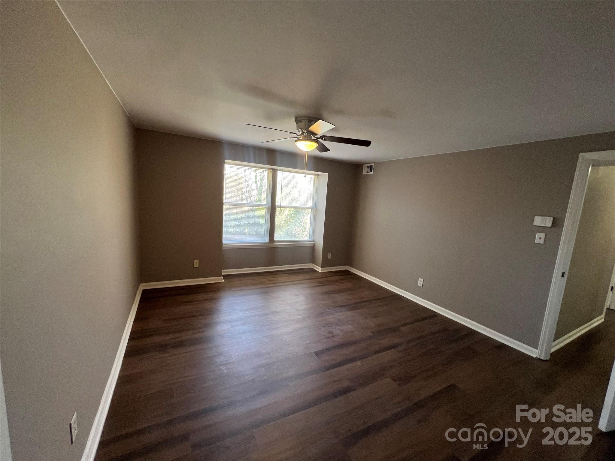 9401 Old Concord Road, Unit K Charlotte, NC 28213 - Photo 5 of 12 an empty room with wooden floor and windows