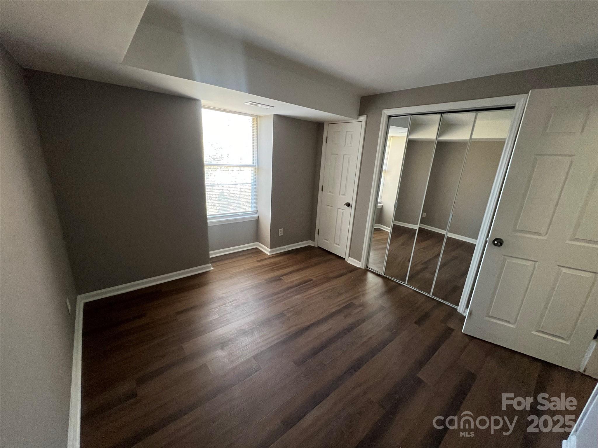9401 Old Concord Road, Unit K Charlotte, NC 28213 - Photo 9 of 12 an empty room with wooden floor and window