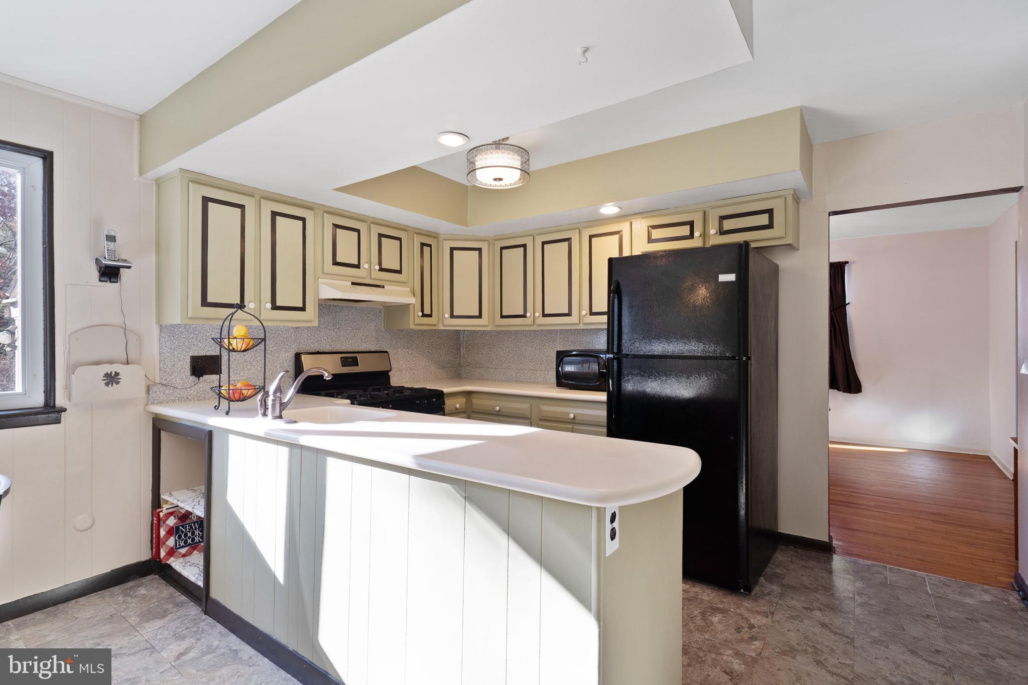 303 Highland Road Cheltenham, PA 19012 - Photo 5 of 25 a kitchen that has a refrigerator a stove and a sink with wooden floor