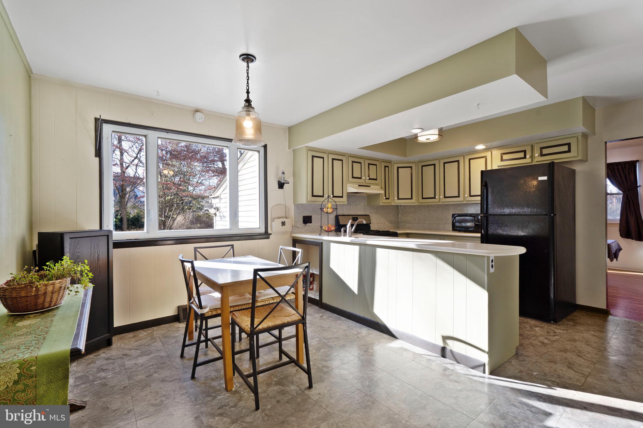303 Highland Road Cheltenham, PA 19012 - Photo 7 of 25 a kitchen with stainless steel appliances granite countertop a kitchen island hardwood floor sink stove dining table and chairs