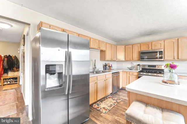 a kitchen with stainless steel appliances granite countertop a refrigerator sink and stove