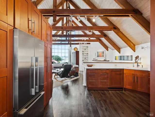 a kitchen with a refrigerator and wooden floor