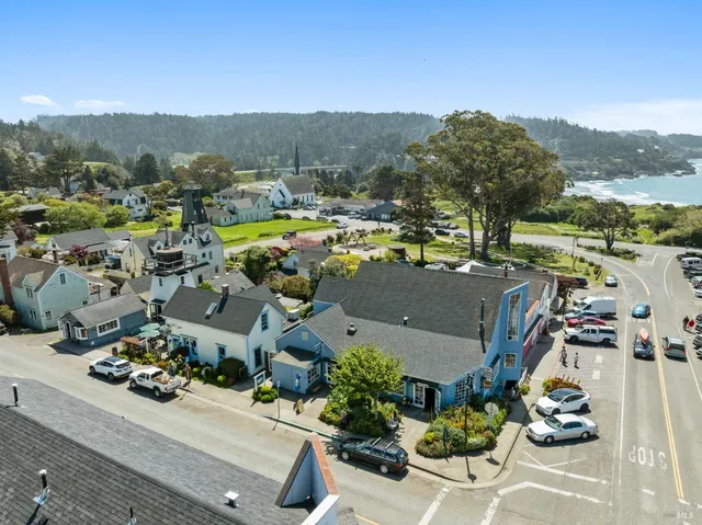 an aerial view of a town with swimming pool and mountains