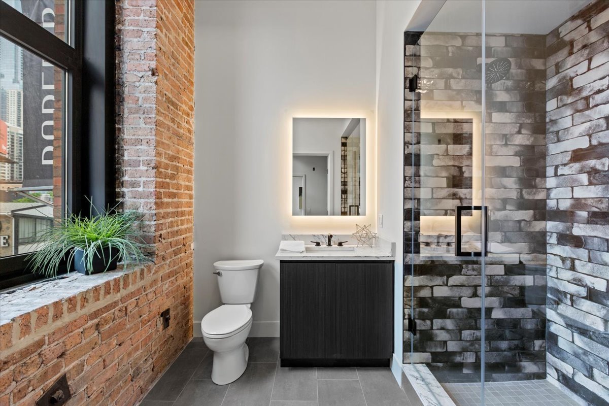 153 West Ohio Street, Unit 202 Chicago, IL 60654 - Photo 7 of 11 a bathroom with a sink a toilet and shower