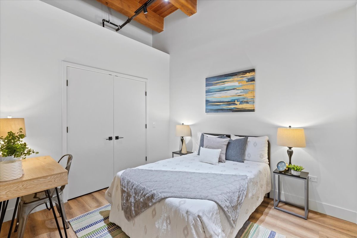153 West Ohio Street, Unit 202 Chicago, IL 60654 - Photo 8 of 11 a bedroom with a bed and a table in it