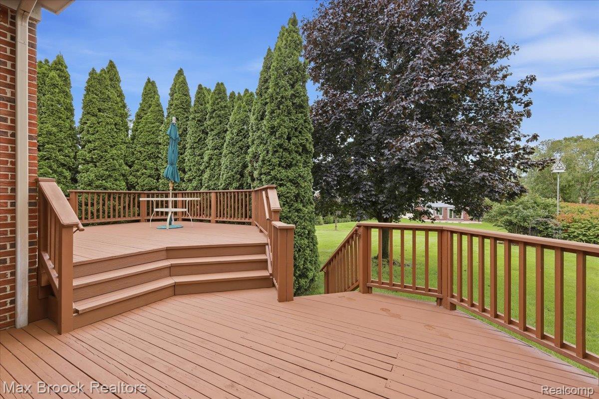 1731 Rico Road Commerce Township, MI 48382 - Photo 44 of 48 Expansive wood-finish deck with multiple levels, wood balusters, and a brick exterior wall
