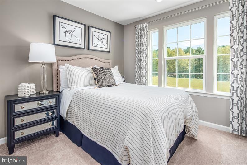 7920 Mine Run Road, Unit MOZART Hanover, MD 21076 - Photo 12 of 27 a bedroom with a bed and a lamp on dresser