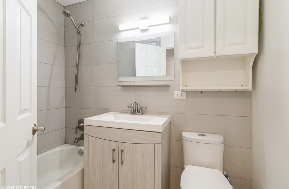 1525 Sander Court, Unit 113 Wheeling, IL 60090 - Photo 11 of 22 a bathroom with a sink a toilet and mirror