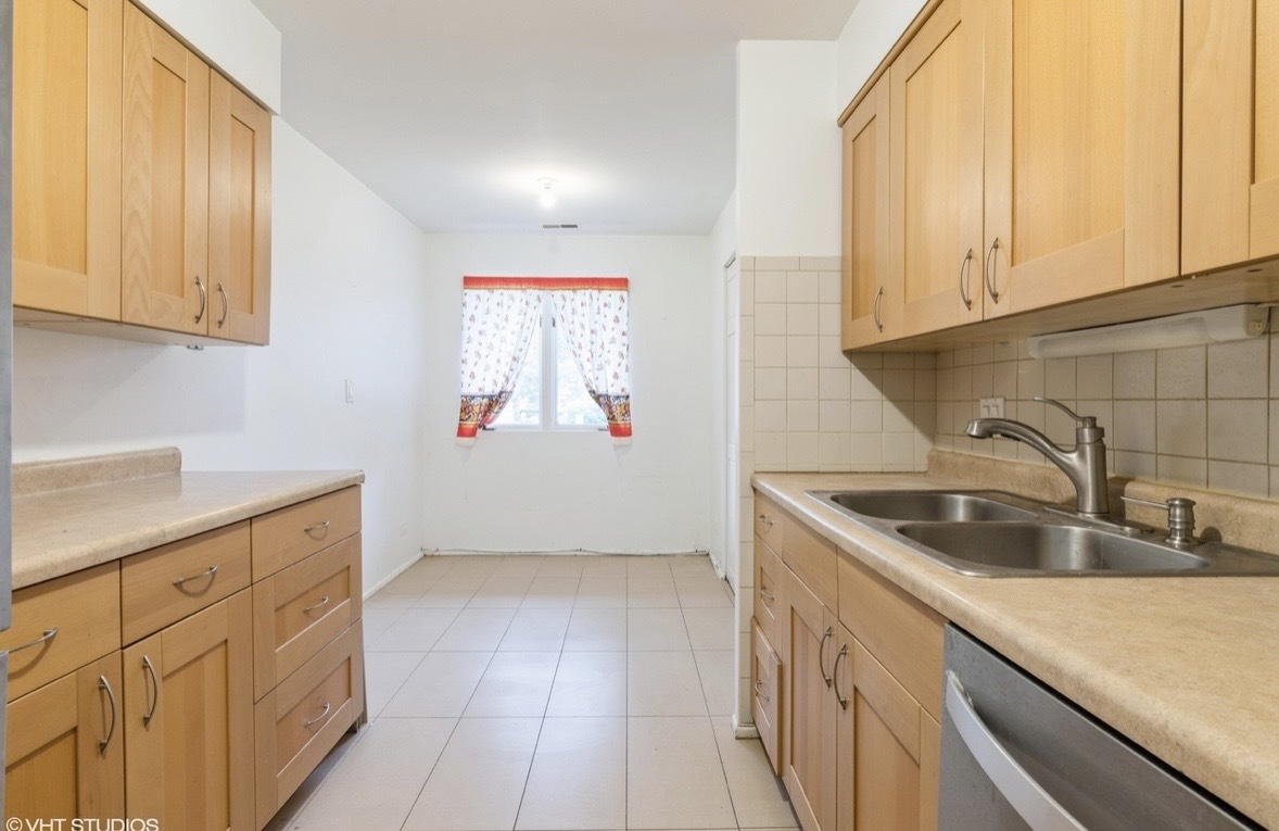 1525 Sander Court, Unit 113 Wheeling, IL 60090 - Photo 7 of 22 a kitchen with granite countertop white cabinets and sink