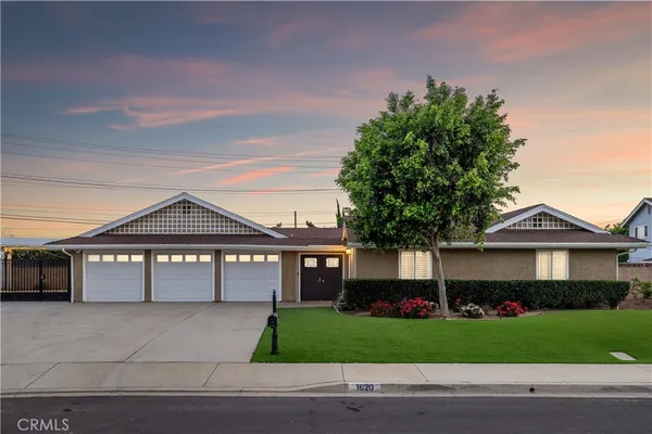 a front view of a house with a garden and garage