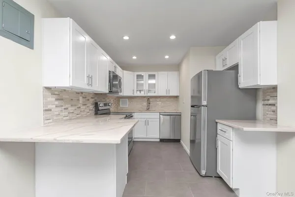 a kitchen with a refrigerator a sink and white cabinets