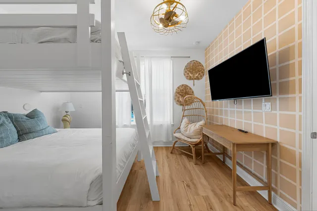 a kitchen with a sink and a stove with wooden floor