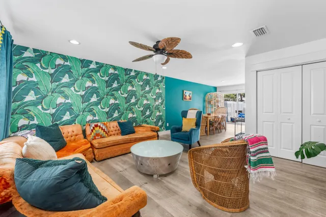 a view of kitchen with kitchen island a sink wooden floor and living room view