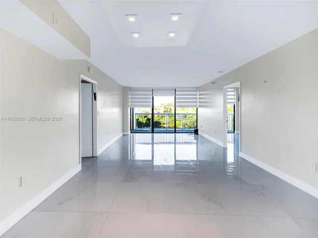 an empty room with floor to ceiling window and an outdoor view